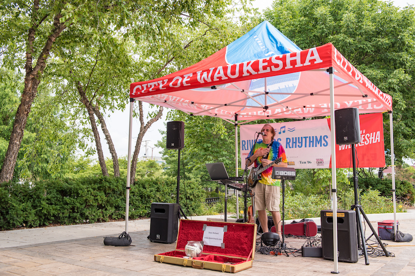 A musician performing at riverside rhythms.